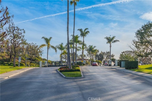 view of street with curbs, sidewalks, and a gate