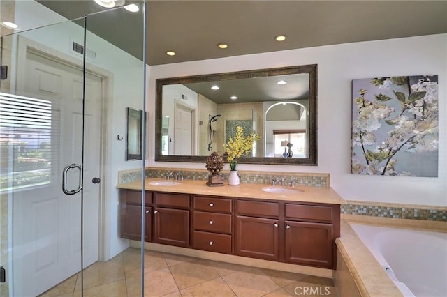 full bathroom with double vanity, visible vents, a stall shower, and a sink