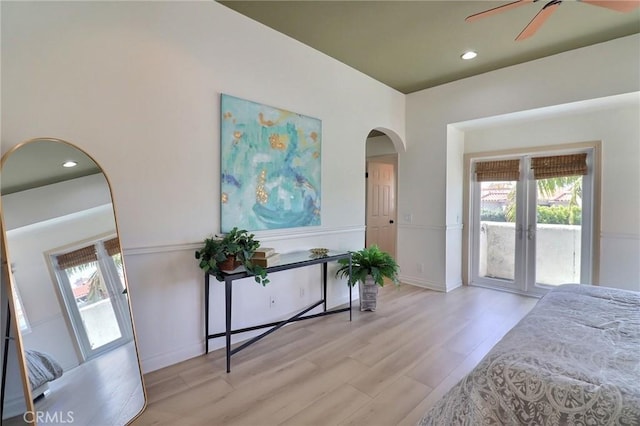 bedroom featuring access to outside, recessed lighting, arched walkways, and light wood-type flooring