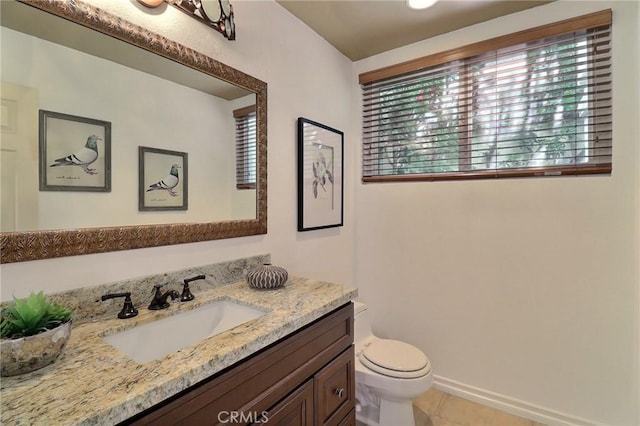 bathroom featuring tile patterned floors, toilet, vanity, and baseboards