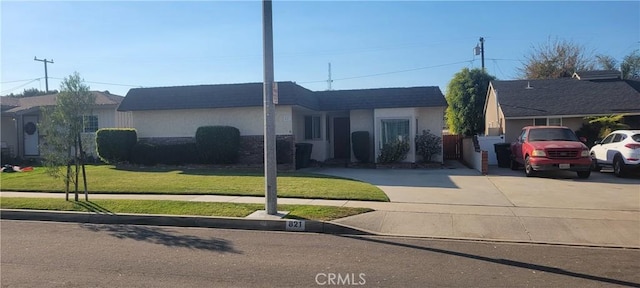 single story home featuring driveway, a front yard, and stucco siding