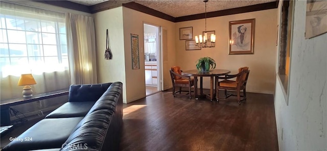 dining space featuring a healthy amount of sunlight, a notable chandelier, dark wood finished floors, and a textured ceiling