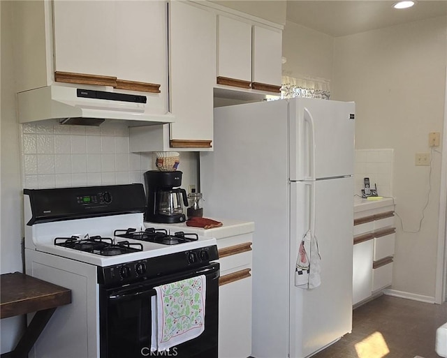 kitchen featuring under cabinet range hood, backsplash, freestanding refrigerator, and range with gas stovetop