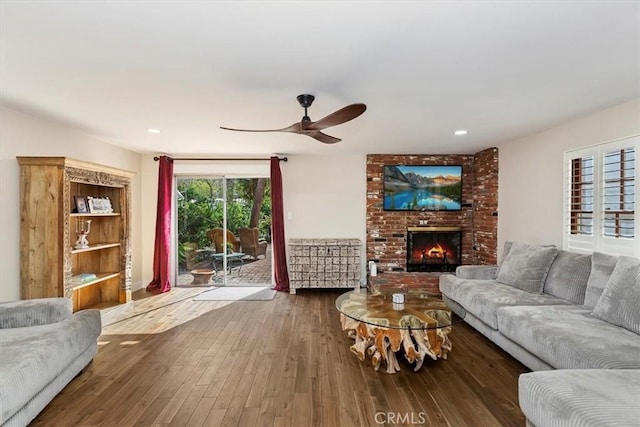 living room with a fireplace, a ceiling fan, wood finished floors, and recessed lighting