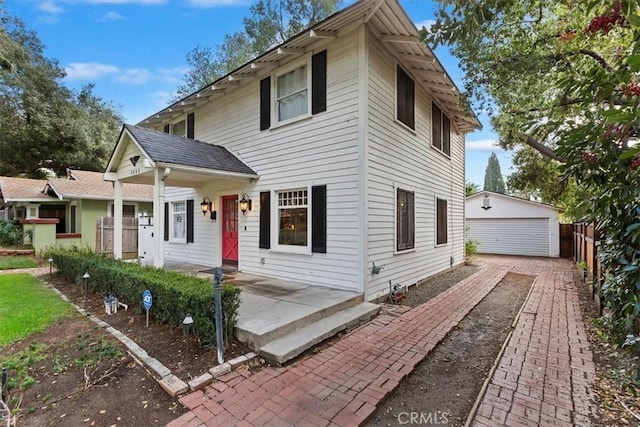 view of front of house featuring a garage, fence, and an outbuilding