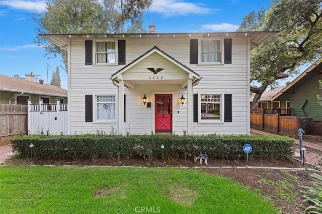 view of front of home with a front lawn and fence