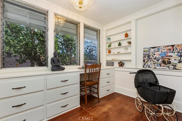 office area with crown molding, dark wood-type flooring, and built in desk