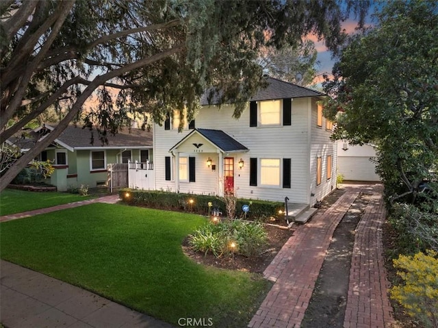 colonial home with aphalt driveway and a front lawn