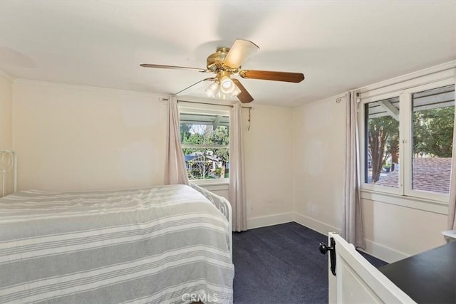 bedroom featuring baseboards, dark carpet, and a ceiling fan