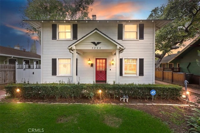 view of front facade featuring a yard and fence