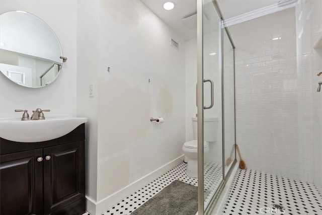 bathroom with a stall shower, baseboards, visible vents, toilet, and vanity