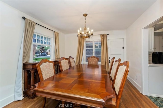 dining space with a notable chandelier, baseboards, and wood finished floors