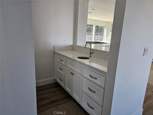 bathroom featuring wood finished floors, vanity, and baseboards