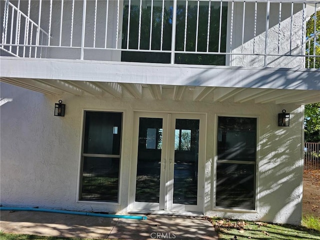 property entrance featuring a balcony and french doors