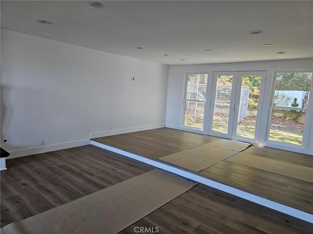 interior space with baseboards, wood finished floors, and recessed lighting