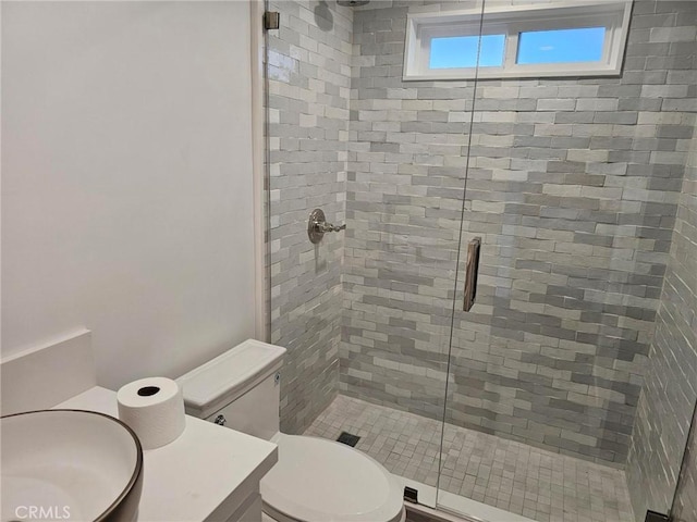 bathroom featuring a stall shower, a sink, and toilet