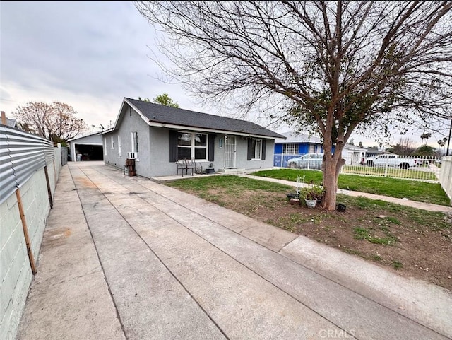 view of front facade with stucco siding, a garage, a front yard, and fence