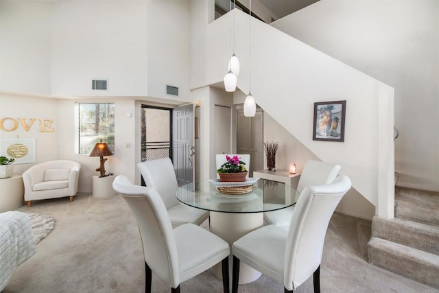 dining area featuring a high ceiling, carpet, and visible vents