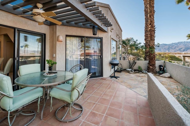 view of patio / terrace featuring a pergola, a mountain view, a ceiling fan, and outdoor dining space