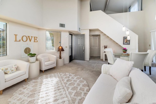 carpeted living room with a high ceiling and visible vents