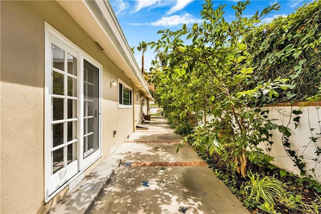 view of property exterior featuring a patio area, fence, and stucco siding