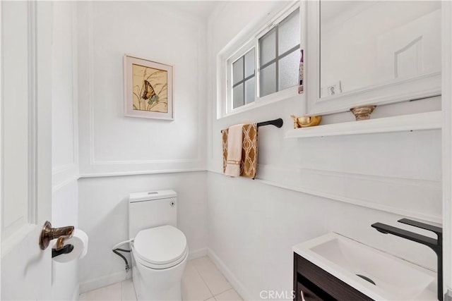 bathroom featuring baseboards, vanity, toilet, and tile patterned floors