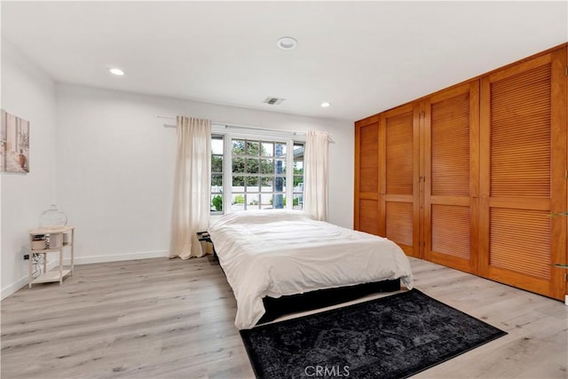 bedroom with recessed lighting, a closet, baseboards, and light wood finished floors