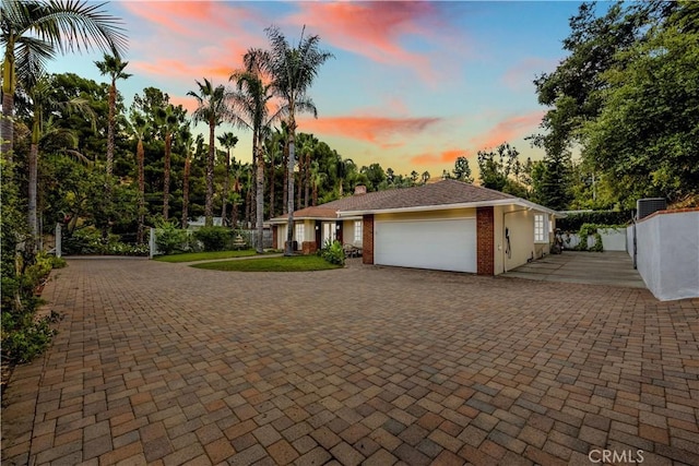 exterior space with a garage, decorative driveway, and brick siding