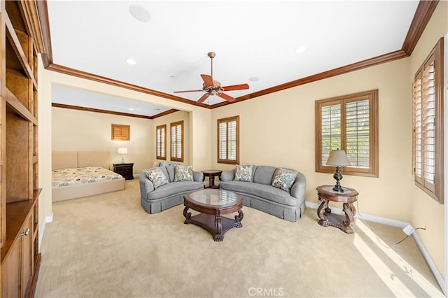 carpeted living area featuring a healthy amount of sunlight, ornamental molding, baseboards, and ceiling fan