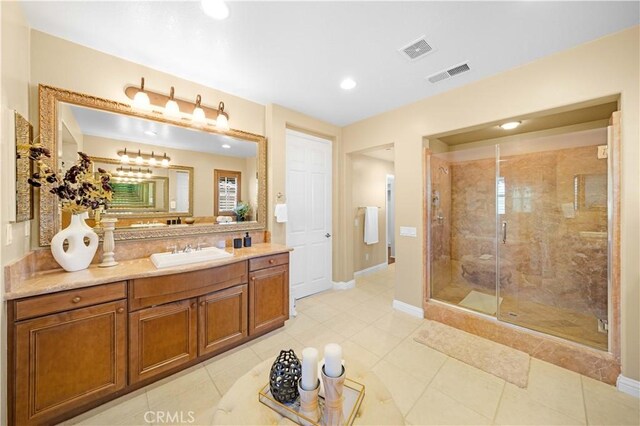 full bathroom with vanity, a shower stall, visible vents, and tile patterned flooring