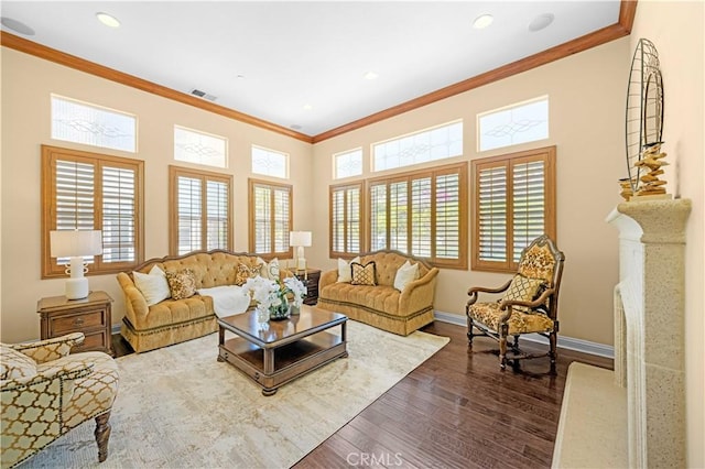 living area featuring a wealth of natural light, ornamental molding, and dark wood finished floors