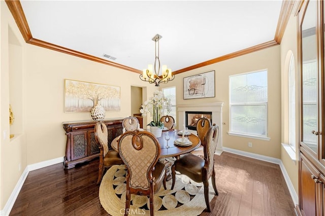 dining space featuring a chandelier, baseboards, and dark wood finished floors