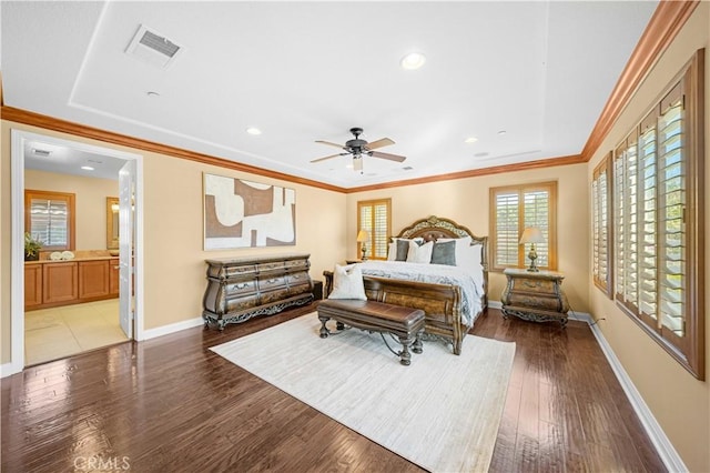 bedroom featuring visible vents, baseboards, wood finished floors, and crown molding