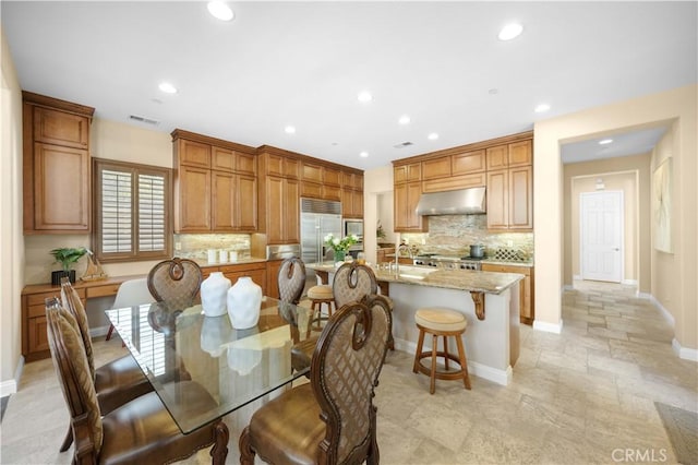 dining area with stone finish flooring, recessed lighting, visible vents, and baseboards