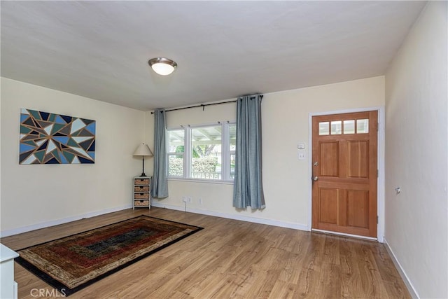 foyer entrance with wood finished floors and baseboards