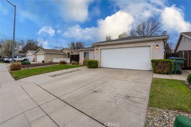 ranch-style house featuring a garage, driveway, fence, and stucco siding