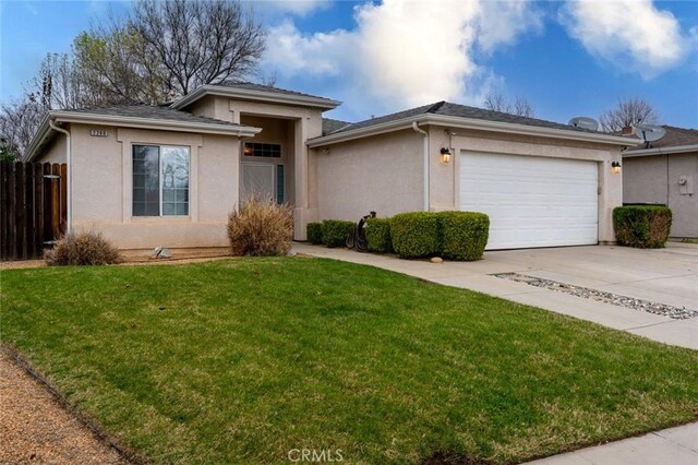 view of front of home with a garage, fence, driveway, stucco siding, and a front yard