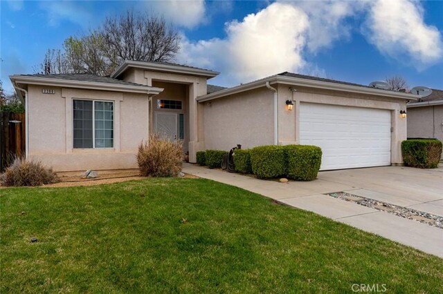 view of front of house with a garage, a front yard, driveway, and stucco siding