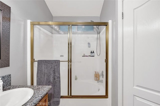 bathroom featuring shower / bath combination with glass door and vanity