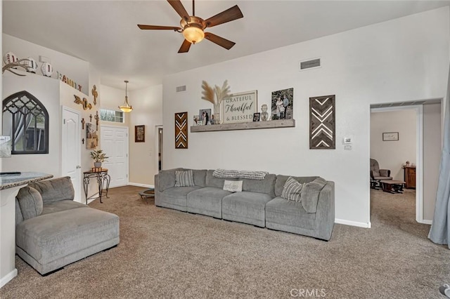 carpeted living area featuring a ceiling fan, visible vents, and baseboards