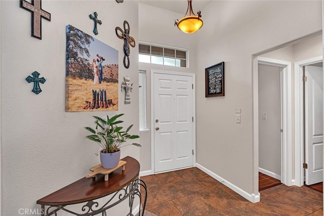 entryway with stone finish floor and baseboards