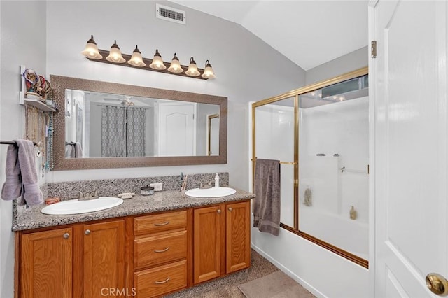 bathroom with lofted ceiling, visible vents, a sink, and double vanity