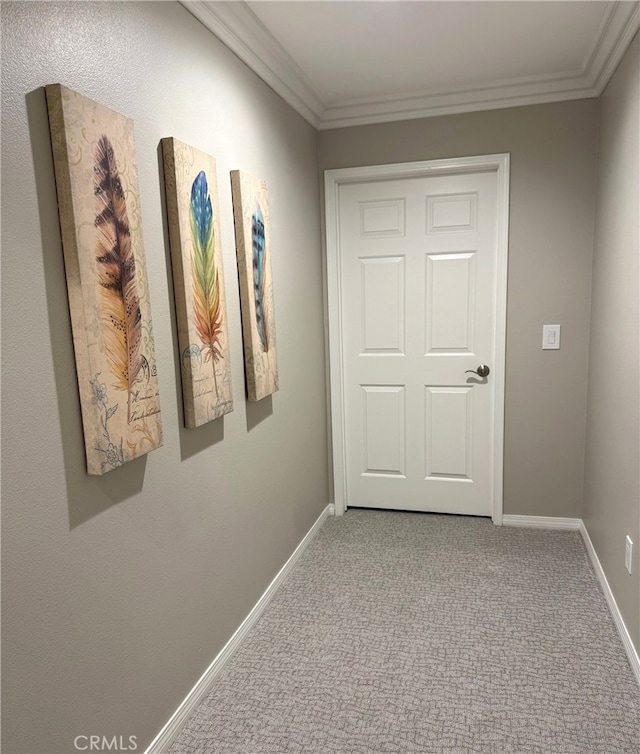 corridor featuring carpet, baseboards, and crown molding