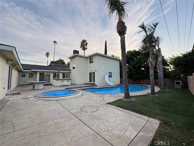 view of swimming pool featuring a fenced in pool, a patio area, an in ground hot tub, a water slide, and a fenced backyard