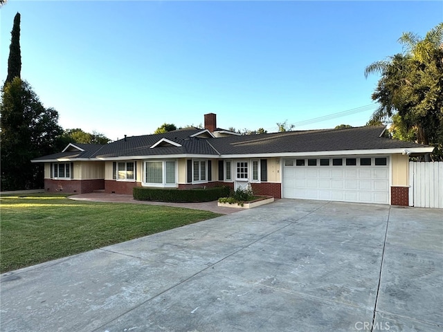 ranch-style home with a garage, concrete driveway, a chimney, a front lawn, and brick siding