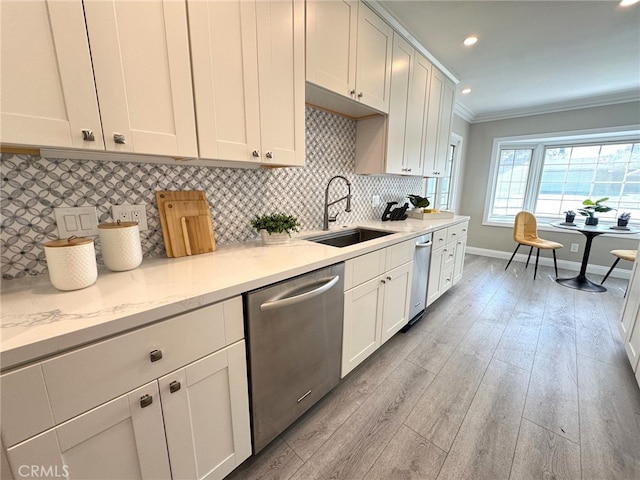 kitchen featuring decorative backsplash, dishwasher, ornamental molding, light wood-type flooring, and a sink