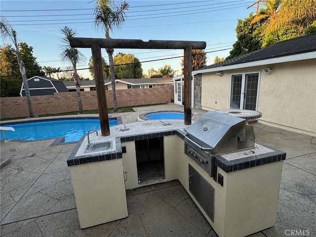 view of patio with exterior kitchen, french doors, a fenced backyard, and a sink