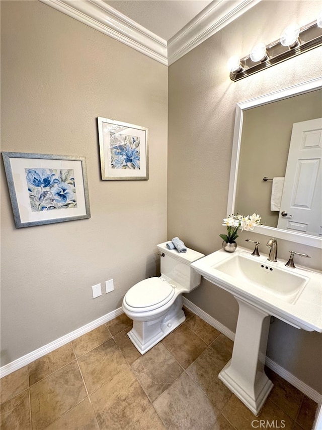 bathroom featuring ornamental molding, tile patterned flooring, toilet, and baseboards