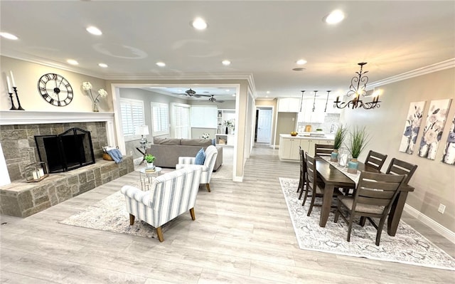 living area with ornamental molding, recessed lighting, a fireplace with raised hearth, and light wood finished floors