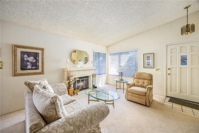 carpeted living area featuring lofted ceiling, a textured ceiling, and a glass covered fireplace